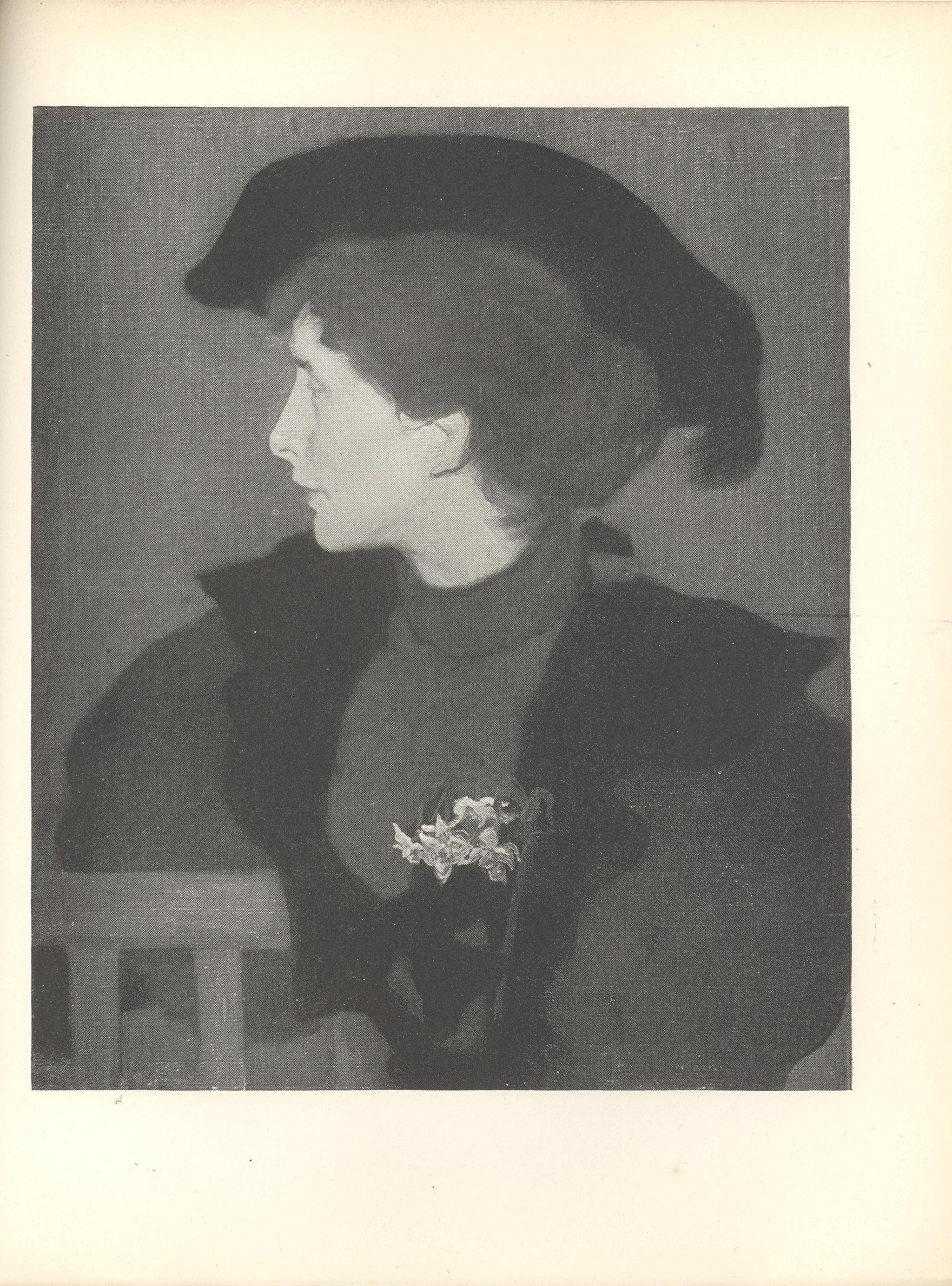 Image is the torso of a seated woman wearing a black hat with feather She is dressed in outside clothes with a white corsage in the lapel of her cloak She is sitting on a chair that s facing frontward with her head turned in profile to the left Her shoulders divide the pictorial space in half horizontally The chair is in the bottom left hand corner of the frame The background is open and dark coloured The image is vertically displayed.