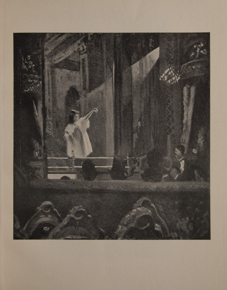 The image is of a small female figure on a stage in a white gown pointing upwards to a balcony She is illuminated by a wide beam of light coming from behind curtain at right There are rounded balconies on either side of the stage In the foreground at the bottom of the image there is a row of chairs with their backs facing the viewer Above the chairs in the middle ground there are the backs of audience members The image is displayed vertically