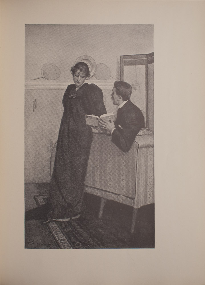 The image is of a seated man showing a standing woman a page from The Yellow Book appears to be Volume III The man is to the right of the woman slightly leaning over the back of a couch with The Yellow Book open The man is in profile and looking towards the woman He has a moustache and is wearing a suit jacket with a collared shirt and a pocket square The woman is leaning against the back of the couch Her hair is done up and she is wearing a long dark coloured dress with large sleeves She is looking at the open page of The Yellow Book The couch and woman both stand on a patterned rug In the background there is a shelf or mantel with a decorative plate and two fans To the right of the shelf or mantel is what appears to be a dressing screen The image is vertically displayed