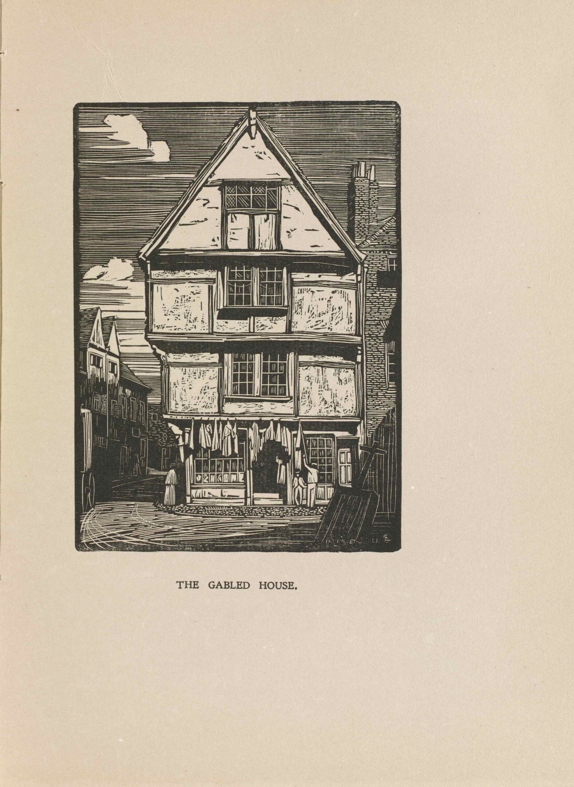 The image is in portrait orientation and is centered on the page within a rectangular border. The image printed in black ink. The front of a lightly coloured Tudor-style house is centered in the foreground of the image. The house is on the corner of a street and is four stories high. There are two-paneled windows in the middle of every story except for the first floor. Each storey slightly increases in length from the bottom to the top, protruding on the left. The house is attached to a bricked building on the right. The brick building is only partially depicted. There are three small figures depicted in the image. Two men are positioned to the right of the house’s front door. One is leaning on the door frame facing forward, and the other is facing towards the front of the house. A woman is standing at the corner of the street, to the left of the house. In the bottom left foreground, a carriage is entering the image. A shovel is positioned close to the front of the image’s bottom right. In the background left, more houses line the street but are darkened by the shadow of the house in the foreground.