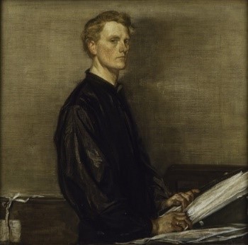 This is a self-portrait oil painting of Charles Haslewood Shannon. Shannon is in a standing position and his body can be seen from the hips up. His body is turned to the right and his face is turned slightly to the centre so that ¾ of his body and face are visible. He is wearing a black shirt with loose fitting fabric in the sleeves that is cuffed at his wrists. He has short blonde hair. He is standing at a desk. His hands are resting on a large closed book with the fingers of his left hand inserted into the first pages. He has a plain ring band on his right ring finger. Papers lie across the desk, either maps or pictures (difficult to determine). Behind Shannon, in the bottom left corner of the picture, it appears that the green-grey wallpaper is peeling.
